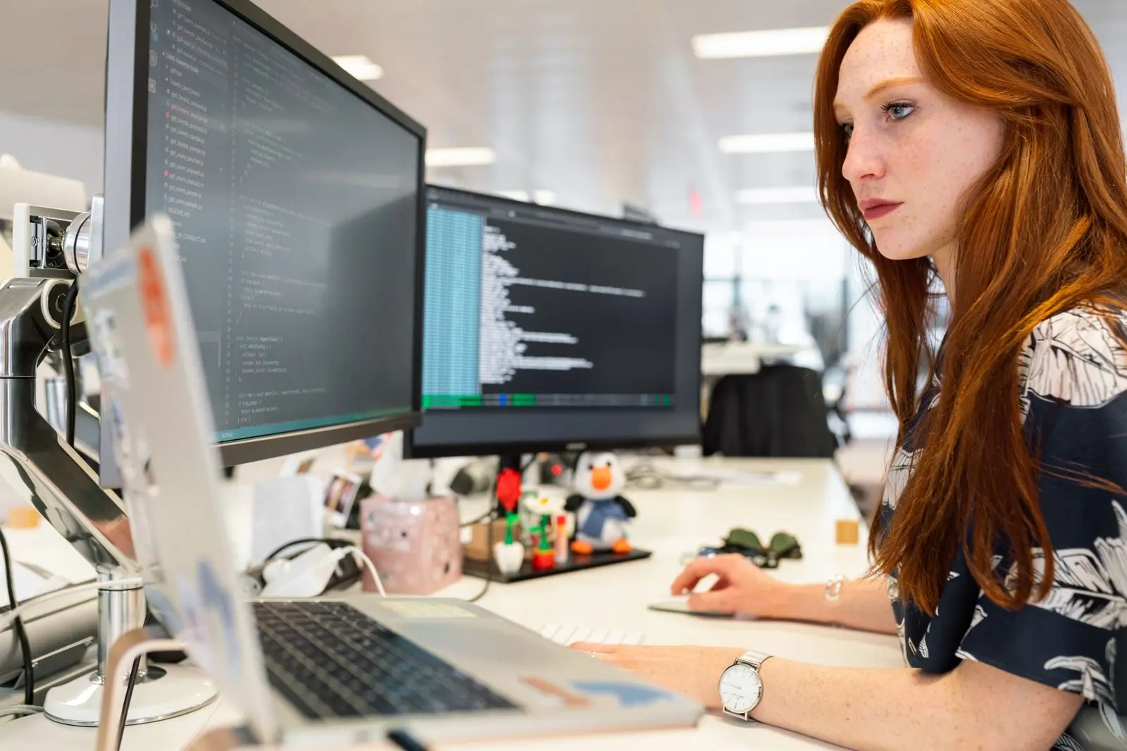 An engineer working at dual computer monitors in an office