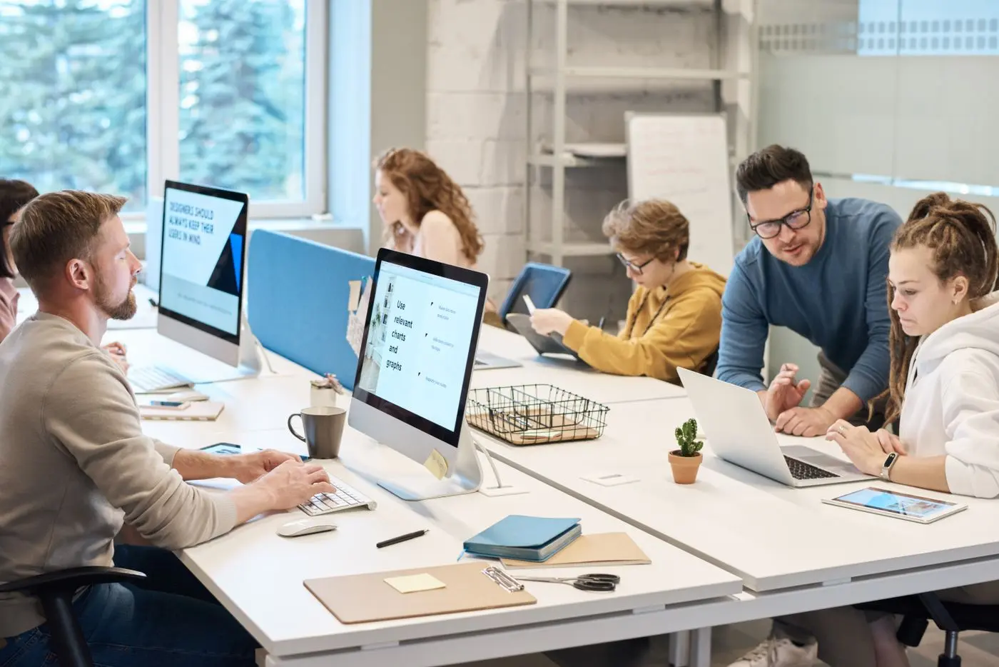 Colleagues collaborating at computers in a shared office